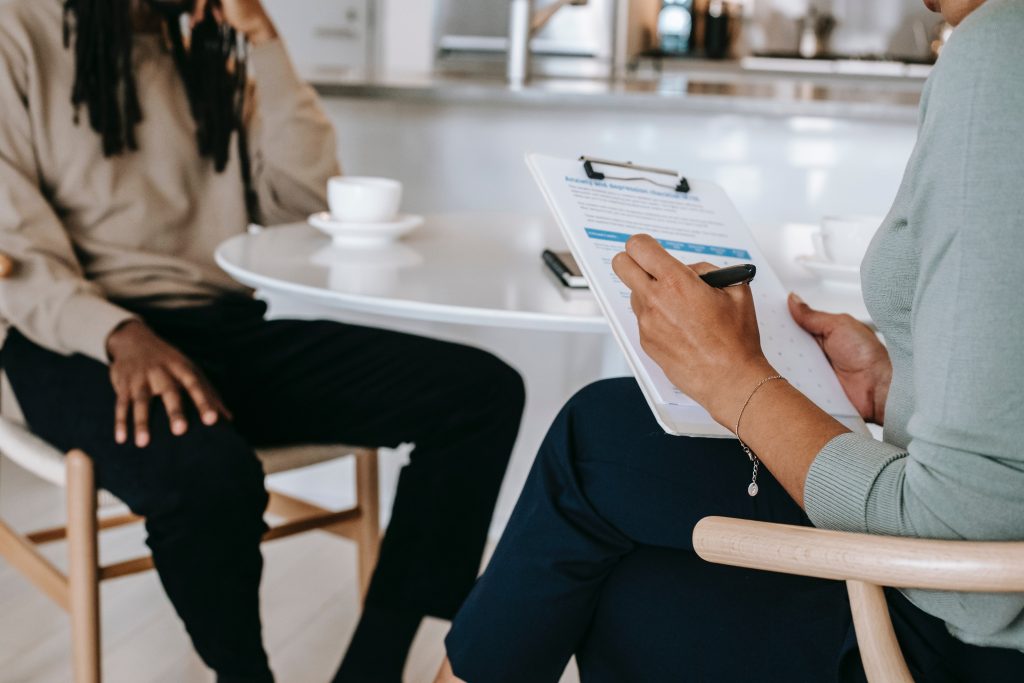 A person interviewing another person with a clipboard