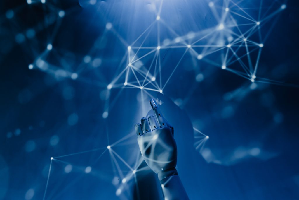 A mannequin hand reaches through a web of technology
