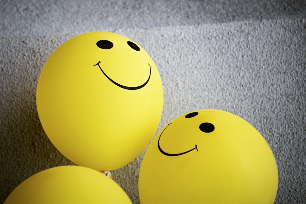 A collection of balloons with smiley faces on them.